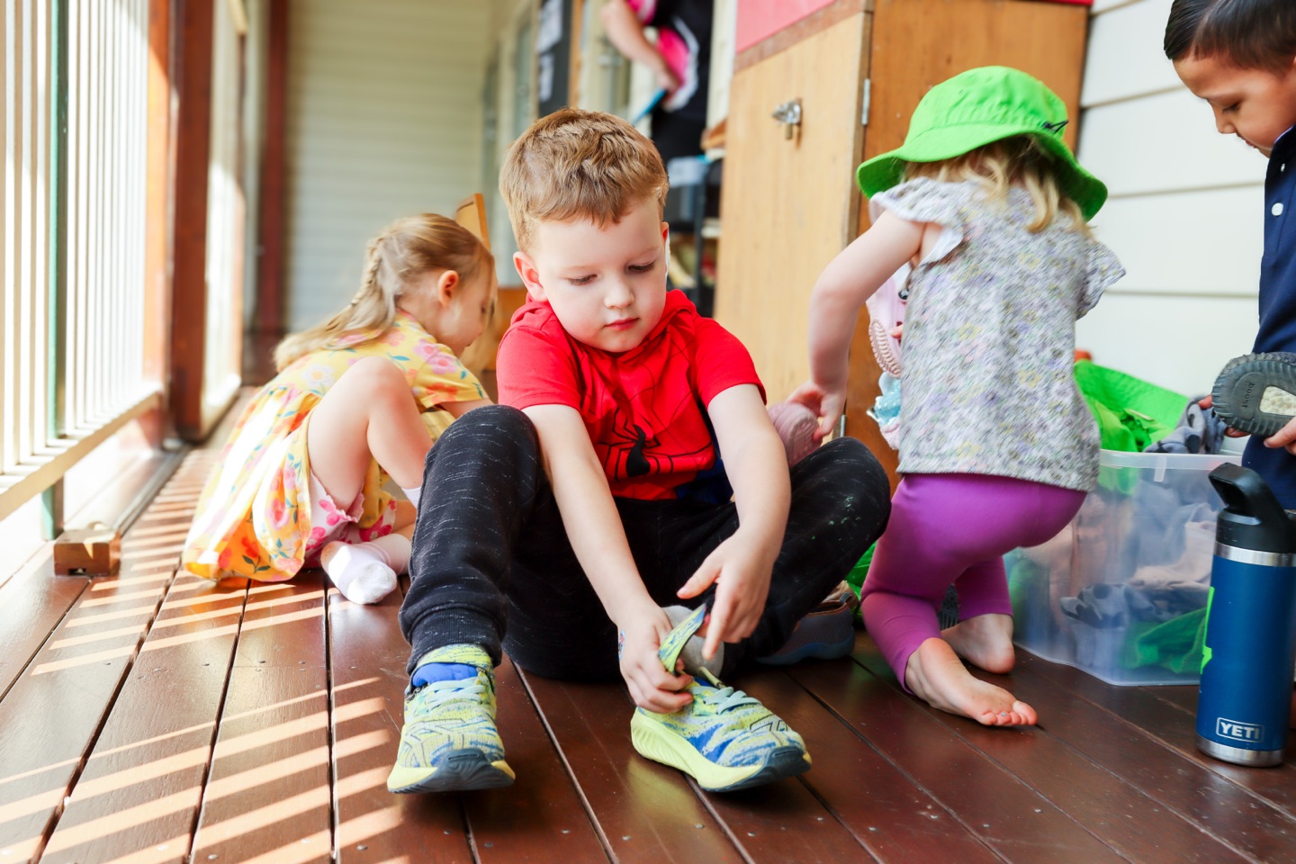 Children putting on their own shoes